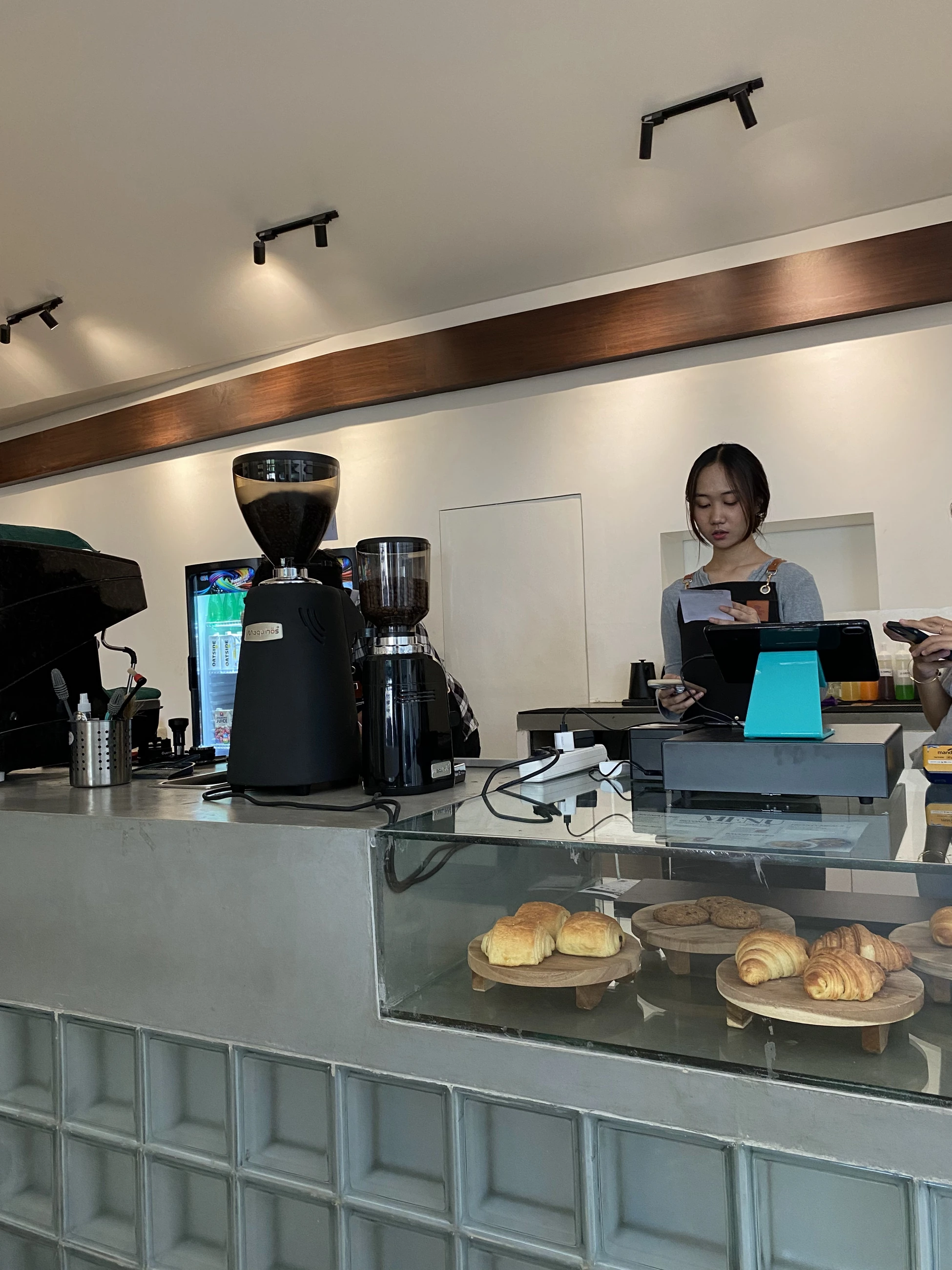 Bar kopi SIXTYNINE dengan mesin grinder dan etalase pastry